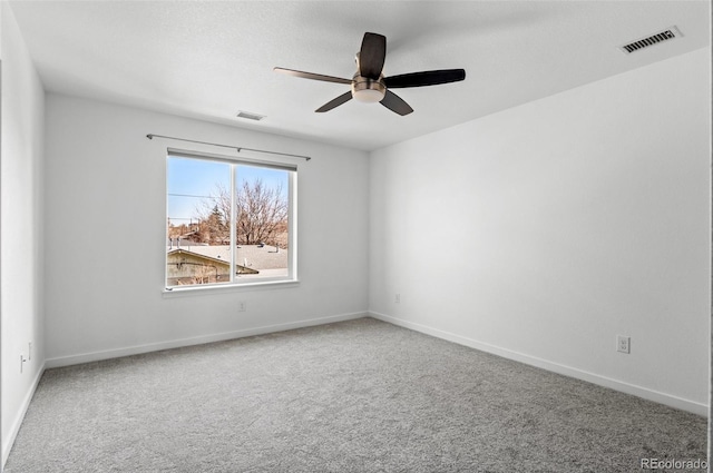 spare room featuring baseboards, carpet, visible vents, and ceiling fan