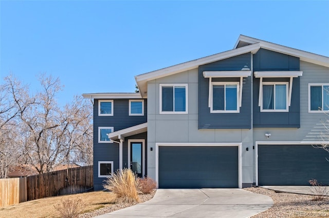 view of front of property featuring concrete driveway, a garage, and fence