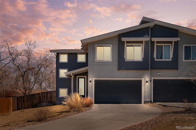 view of front of house with an attached garage, fence, and driveway