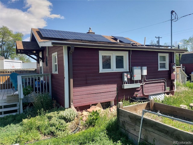 1314 16th Ave, Greeley, CO 80631 - back of property with solar panels, a deck, and a chimney