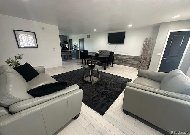 living area featuring light wood finished floors and recessed lighting