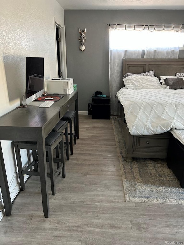 bedroom with multiple windows and light wood finished floors