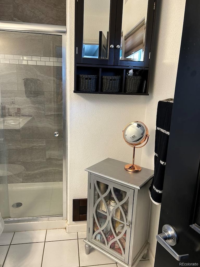 full bath featuring tile patterned flooring and a shower stall