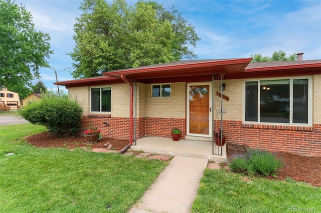 8675 Calvin Dr, Arvada, CO 80002 - view of front of home with brick siding, a front yard, and a patio area