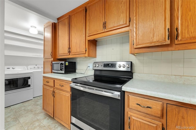 8675 Calvin Dr, Arvada, CO 80002 - kitchen featuring stainless steel appliances, washing machine and clothes dryer, light countertops, and backsplash