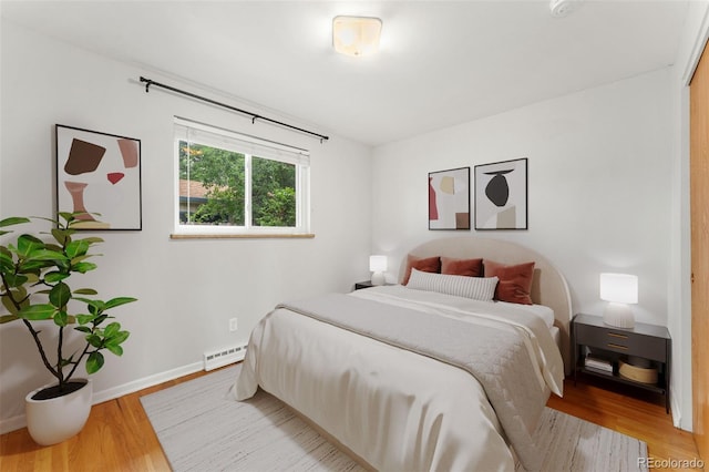 8675 Calvin Dr, Arvada, CO 80002 - bedroom with a baseboard radiator and wood finished floors