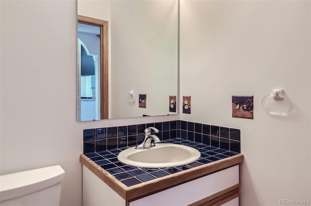 bathroom with backsplash, vanity, and toilet