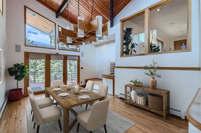 dining room featuring baseboard heating, light hardwood / wood-style floors, high vaulted ceiling, and wooden ceiling