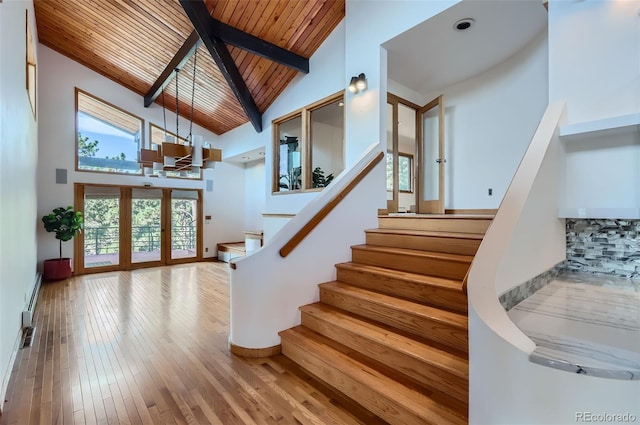 stairs with high vaulted ceiling, french doors, hardwood / wood-style flooring, wooden ceiling, and beam ceiling