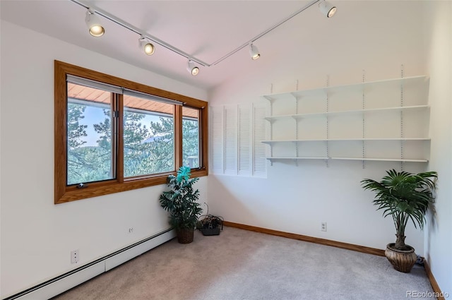 carpeted empty room with track lighting and a baseboard radiator