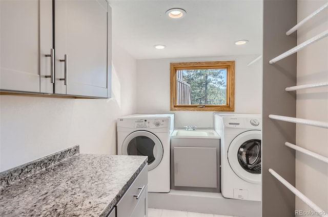 laundry area featuring sink, cabinets, light tile patterned floors, and washer and clothes dryer