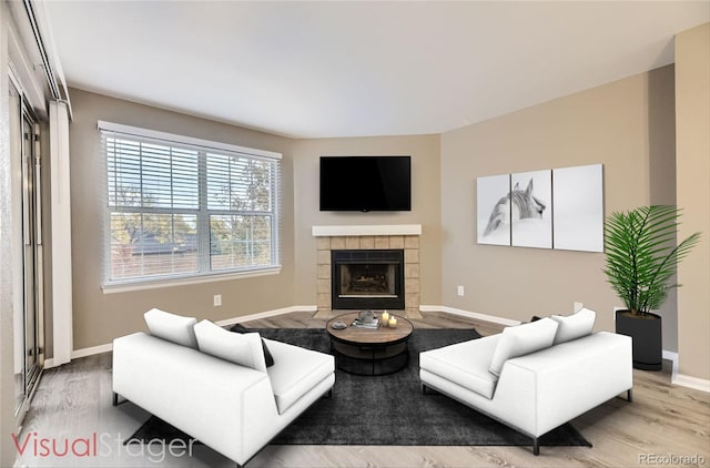 5745 W Atlantic Pl Unit 206, Lakewood, CO 80227 - living area with wood finished floors, a tiled fireplace, and baseboards