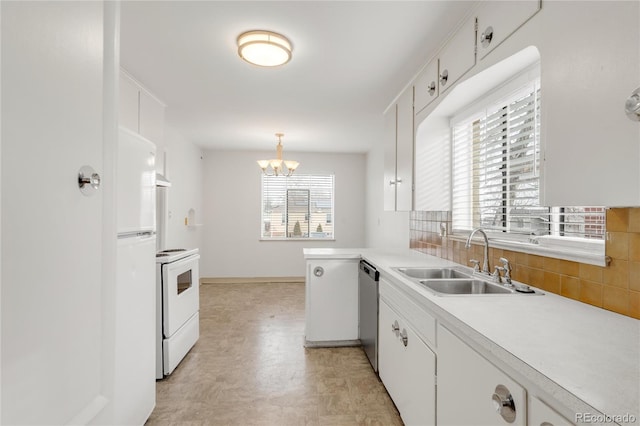 kitchen with sink, white appliances, white cabinetry, hanging light fixtures, and a notable chandelier