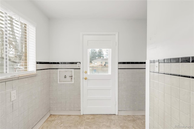 doorway to outside featuring tile walls and light tile patterned floors