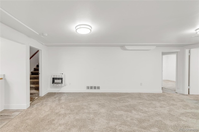 empty room featuring light carpet and heating unit