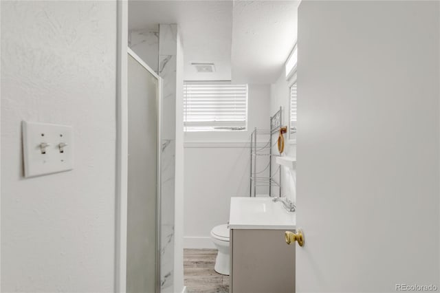 bathroom with vanity, wood-type flooring, a textured ceiling, toilet, and walk in shower