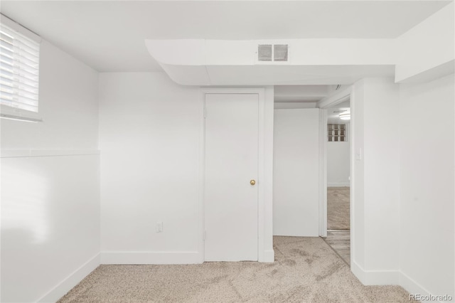 basement featuring light carpet