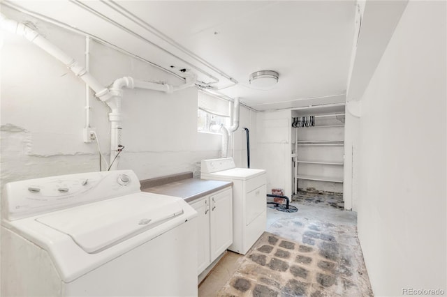 clothes washing area with cabinets and washer and clothes dryer