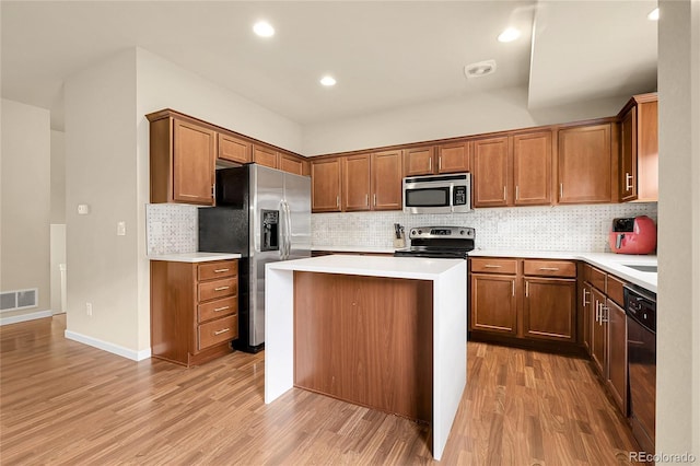 18061 E Saskatoon Pl, Parker, CO 80134 - kitchen with stainless steel appliances, light wood finished floors, light countertops, decorative backsplash, and recessed lighting