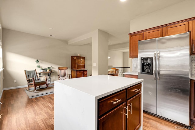 18061 E Saskatoon Pl, Parker, CO 80134 - kitchen with stainless steel refrigerator with ice dispenser, light countertops, light wood-style floors, and a kitchen island