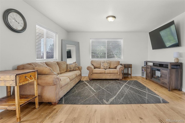 4750 County Road B, Wiggins, CO 80654 - living area featuring plenty of natural light, wood finished floors, and a multi sided fireplace