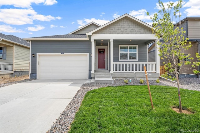 view of front of house featuring a porch, a garage, and a front yard