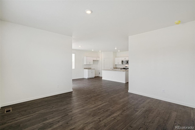 unfurnished living room with dark wood-type flooring