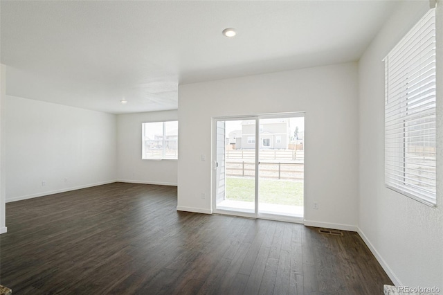 unfurnished room with dark wood-type flooring