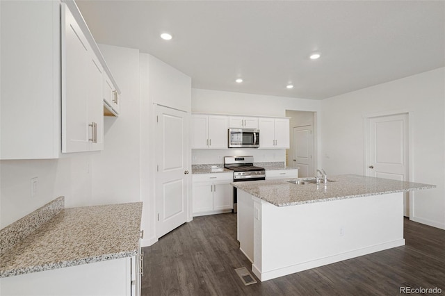 kitchen featuring white cabinets, appliances with stainless steel finishes, sink, and an island with sink