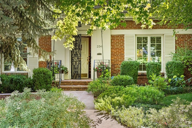 doorway to property with brick siding