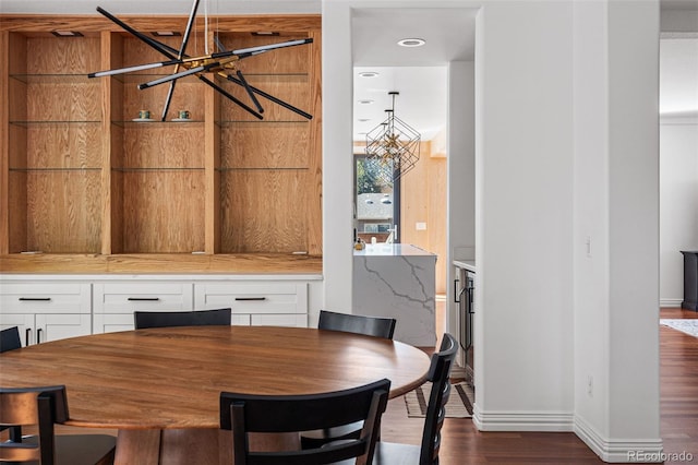 dining room with dark hardwood / wood-style flooring and an inviting chandelier