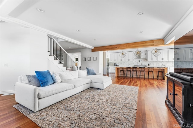 living room featuring beam ceiling and wood-type flooring