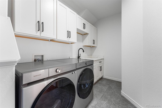 clothes washing area with cabinets, independent washer and dryer, dark tile patterned floors, and sink