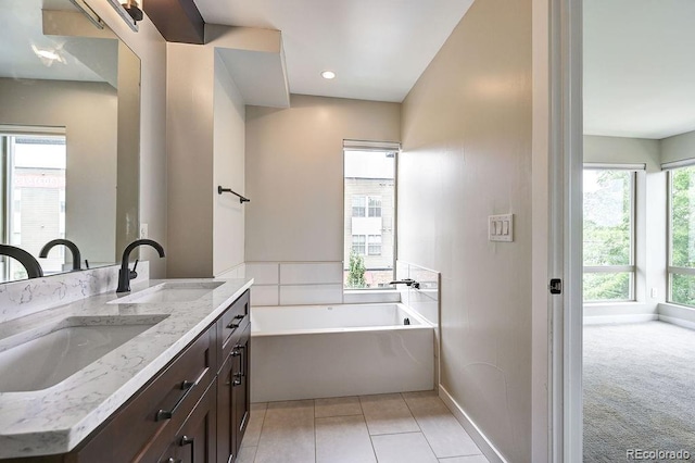 bathroom featuring vanity, tile patterned flooring, and a washtub