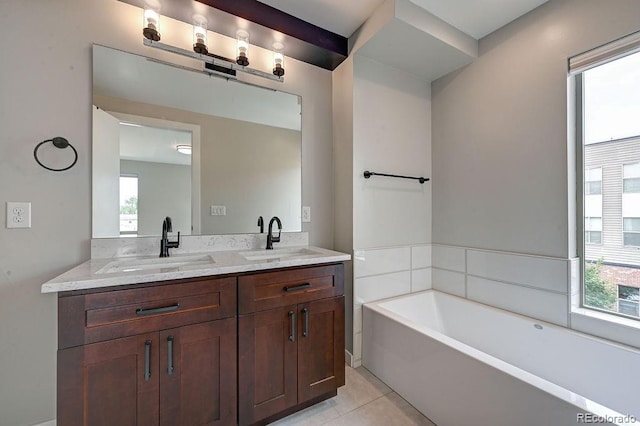 bathroom with a bath, a wealth of natural light, tile patterned flooring, and vanity