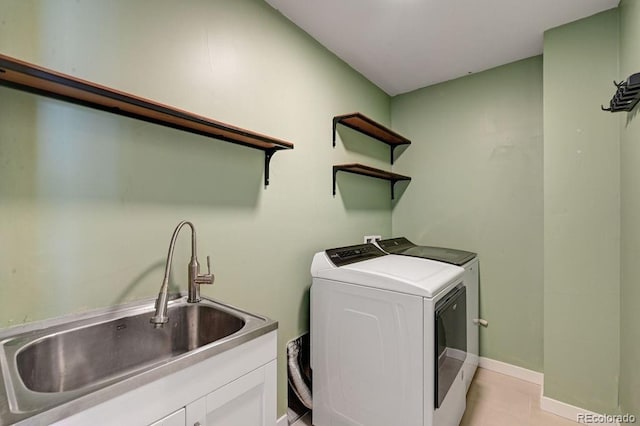 washroom with cabinets, sink, independent washer and dryer, and light tile patterned floors