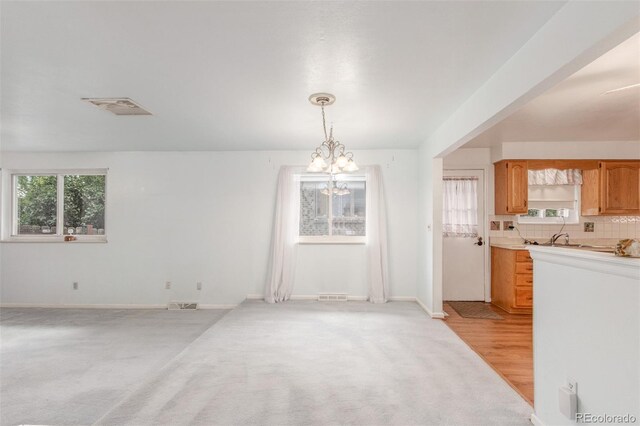 16699 E 7th Ave, Aurora, CO 80011 - unfurnished dining area with a chandelier and light carpet
