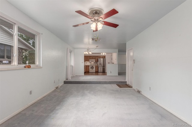 16699 E 7th Ave, Aurora, CO 80011 - unfurnished living room with a ceiling fan, a chandelier, and carpet