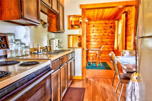 446 Chief Trl, Como, CO 80456 - kitchen featuring electric stove, freestanding refrigerator, a sink, light wood-style flooring, and brown cabinetry