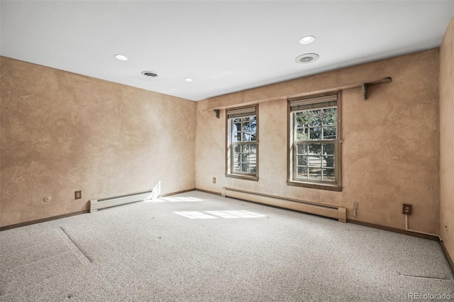 empty room featuring a baseboard heating unit and carpet flooring