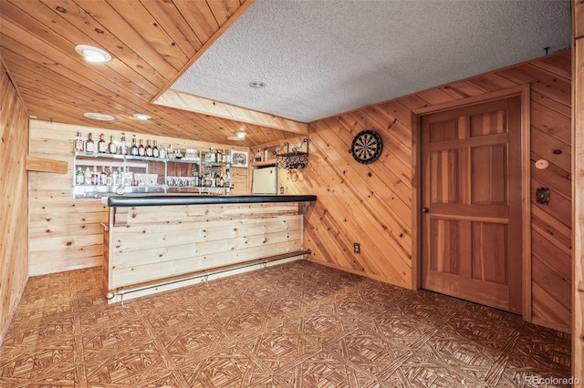 kitchen with a textured ceiling and wooden walls