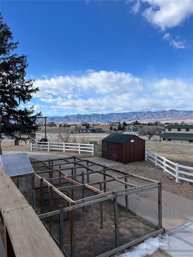 view of yard featuring a mountain view, a rural view, and a storage unit