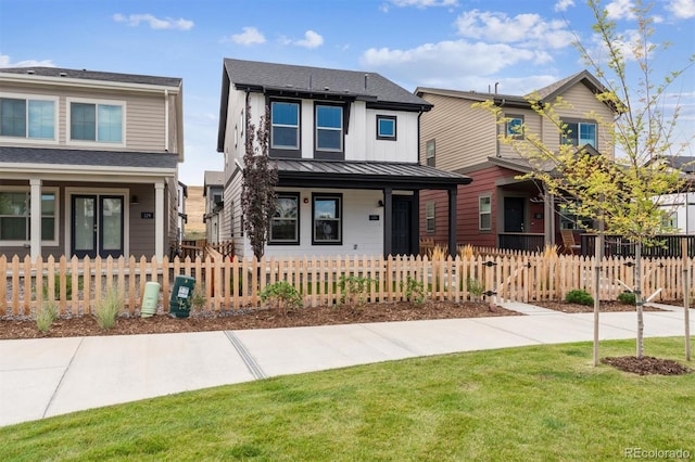 view of front of home featuring a fenced front yard, a standing seam roof, and metal roof