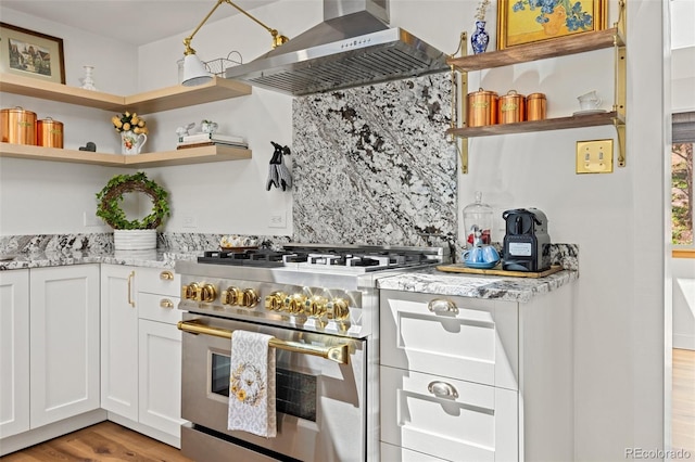 1669 Apple Valley Rd, Lyons, CO 80540 - kitchen featuring high end stainless steel range oven, wall chimney exhaust hood, open shelves, light stone countertops, and light wood finished floors
