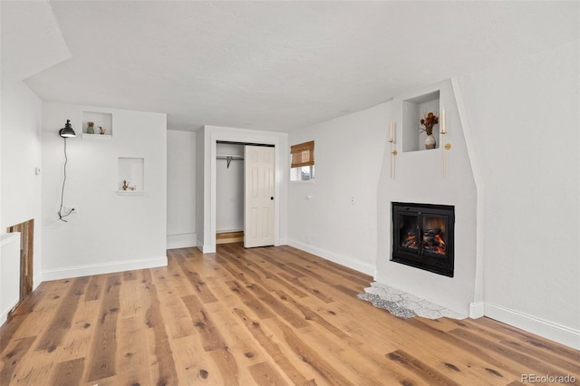1669 Apple Valley Rd, Lyons, CO 80540 - unfurnished living room featuring a fireplace with flush hearth, baseboards, and light wood-style flooring
