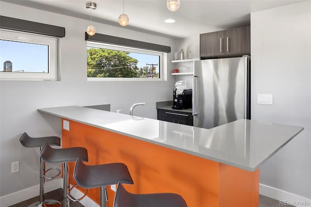 3453 Navajo St, Denver, CO 80211 - kitchen featuring freestanding refrigerator, a breakfast bar, baseboards, light countertops, and open shelves