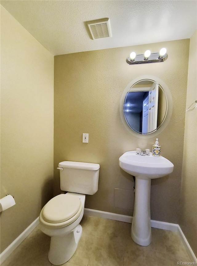 10154 Fairgate Way, Highlands Ranch, CO 80126 - bathroom with toilet, tile patterned flooring, baseboards, and a textured ceiling