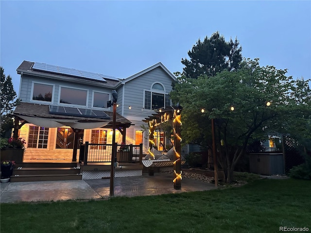 10154 Fairgate Way, Highlands Ranch, CO 80126 - back of house with a deck, roof mounted solar panels, a patio area, and a yard