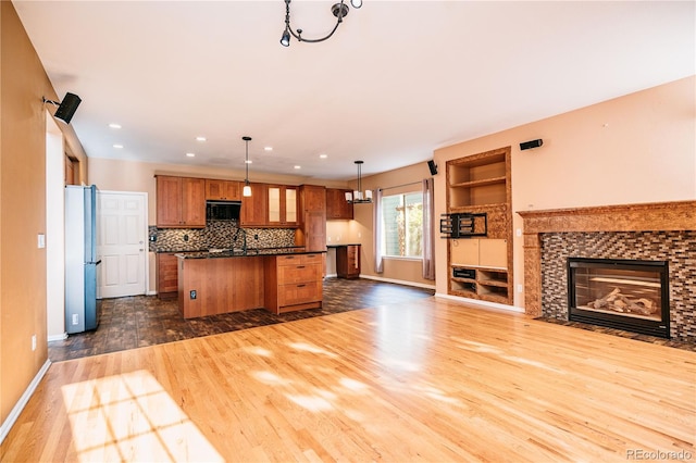 10154 Fairgate Way, Highlands Ranch, CO 80126 - kitchen with open floor plan, freestanding refrigerator, black microwave, dark wood finished floors, and brown cabinets