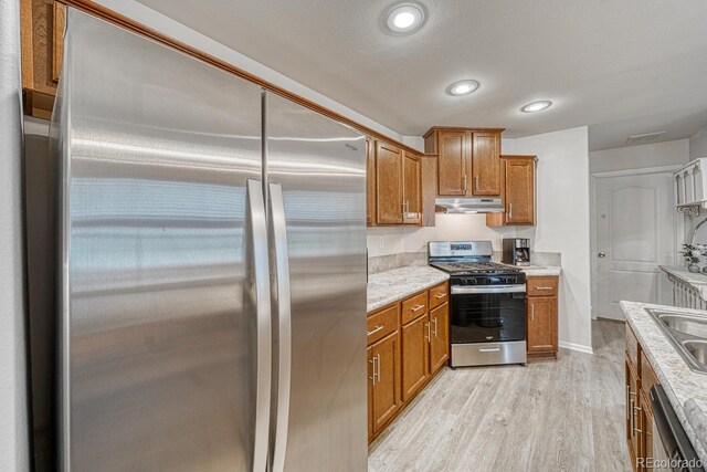 310 Chipeta Ave, Poncha Springs, CO 81242 - kitchen with appliances with stainless steel finishes, under cabinet range hood, brown cabinets, a sink, and recessed lighting